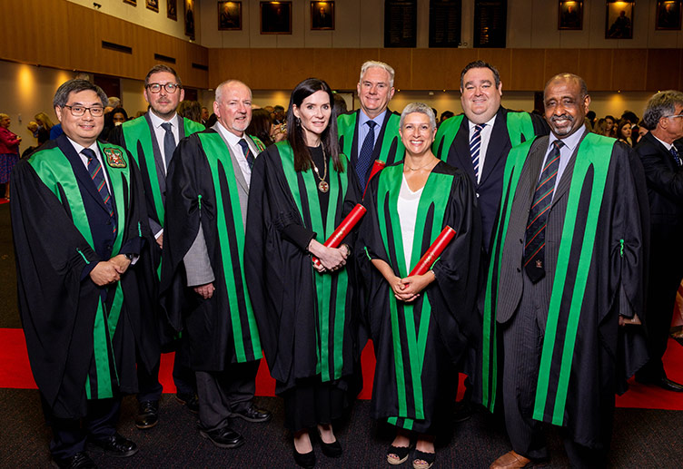A group of conferrees stand together in gowns at the 2024 Faculty of Dentistry Conferring Ceremony