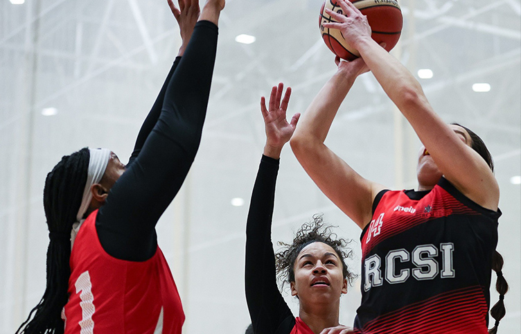 Three members of the RCSI Women’s Basketball team jump for a ball