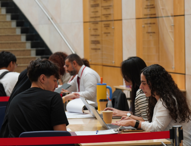 A student consulting with an admissions officer at an application support desk.