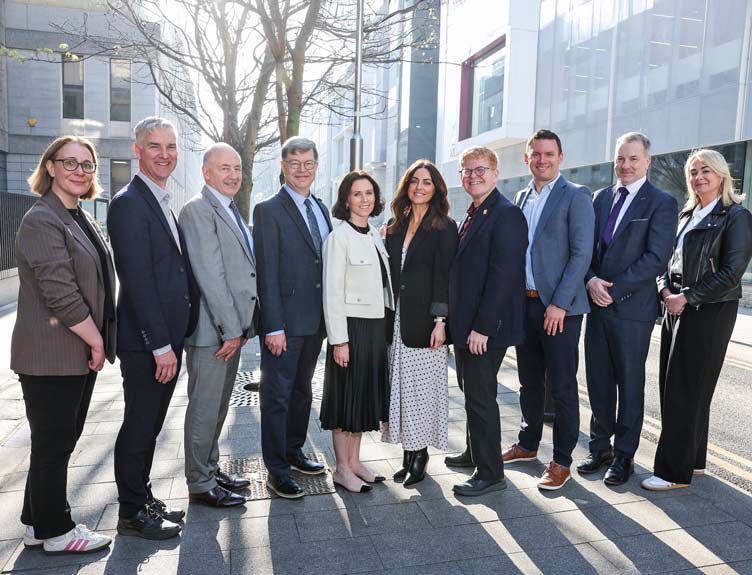 Conference speakers pose in a line for a shot on sunny day