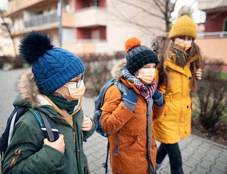People walking in winter clothes and face masks