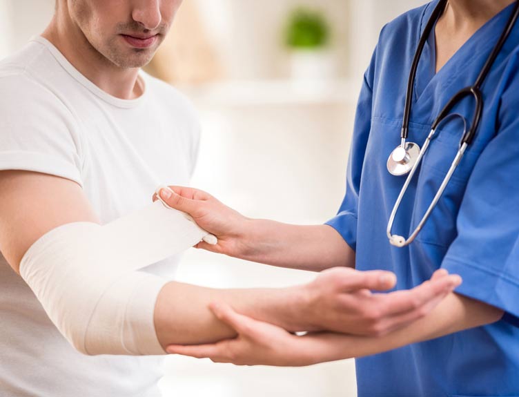 Man with arm fracture is tended to by a nurse