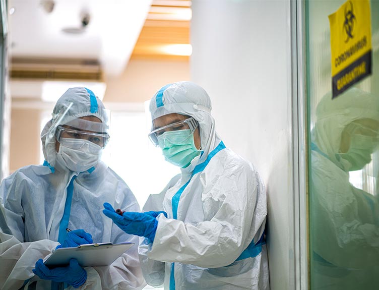 Medical-staff-in-PPE-with-covid-sign