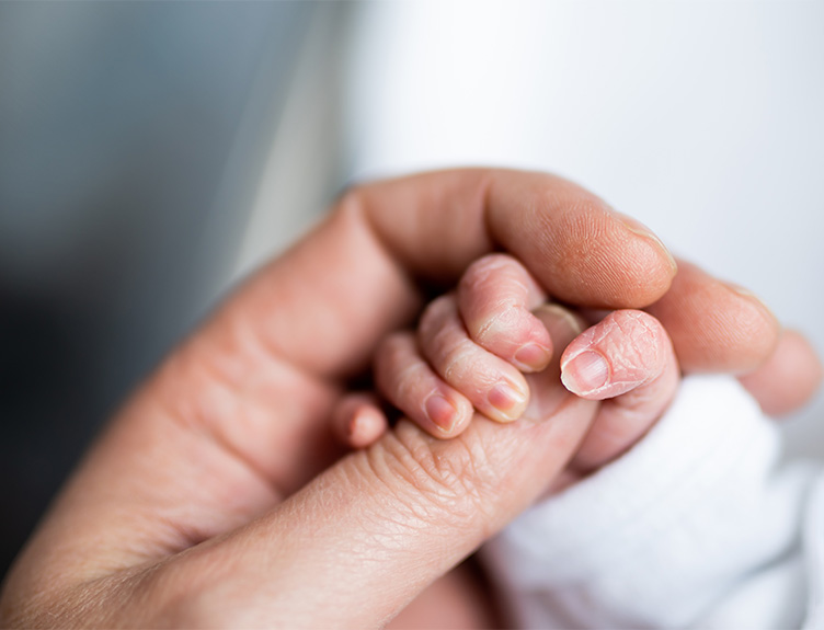 Newborn baby hand with adult hand