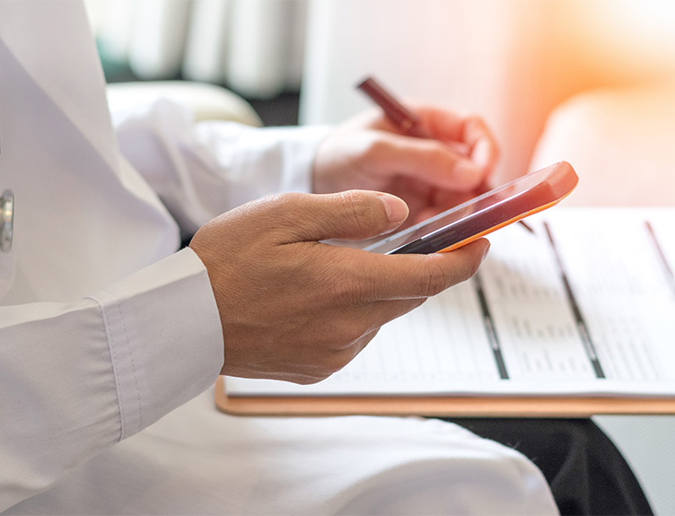 Doctor with mobile and clipboard