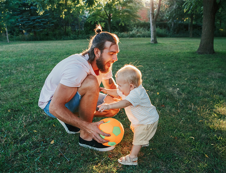 Toddler and adult playing with ball