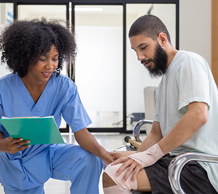 A nurse assists a patient with a knee injury.