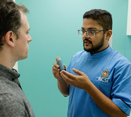 Nurse demonstrating how to use an inhaler