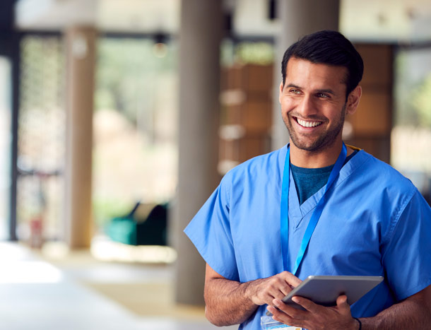 Young doctor wearing scubs hold a tablet computer