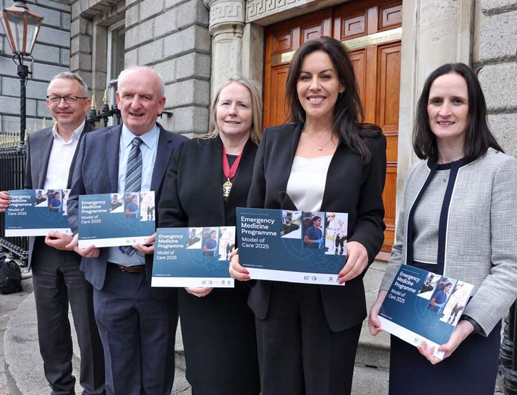 Five people in front of old building hold brochures