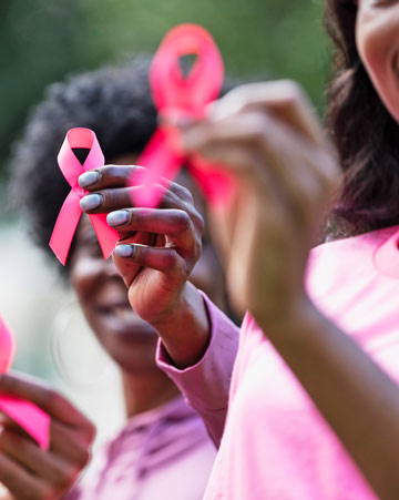 Cropped view of a group of women holding aloft pink ribbons