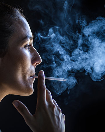 Profile view of woman smoking in the dark