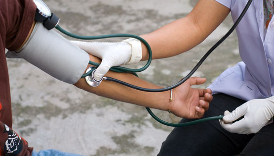 Health professional checking blood pressure of a patient