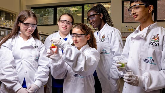 Young students in white coats in a lab
