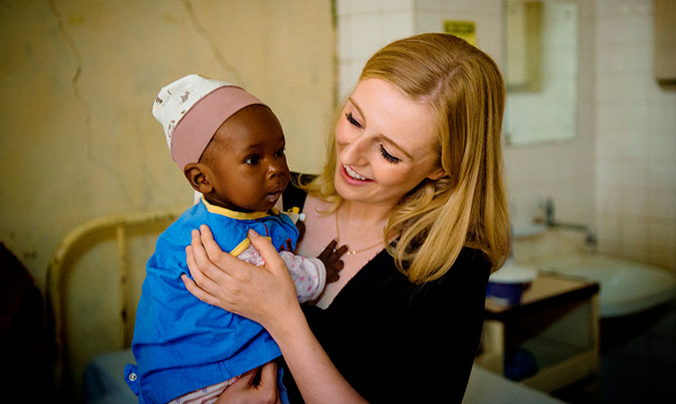 A woman holding a baby in a clinic.