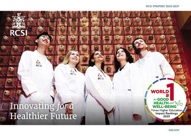 Students in white coats look upwards