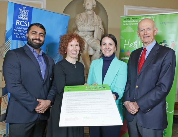 Four individuals hold up a healthy campus charter