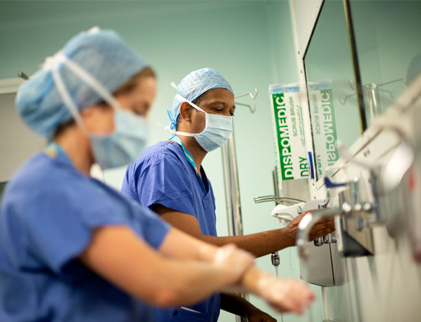 Male and female surgeon scrubbing in