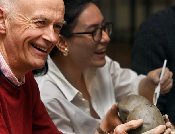 Man smiles while creating a art piece
