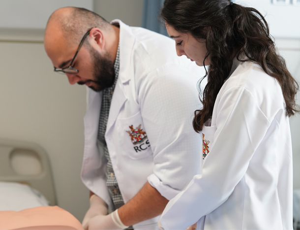 a professor and a student in white lab coats in class.