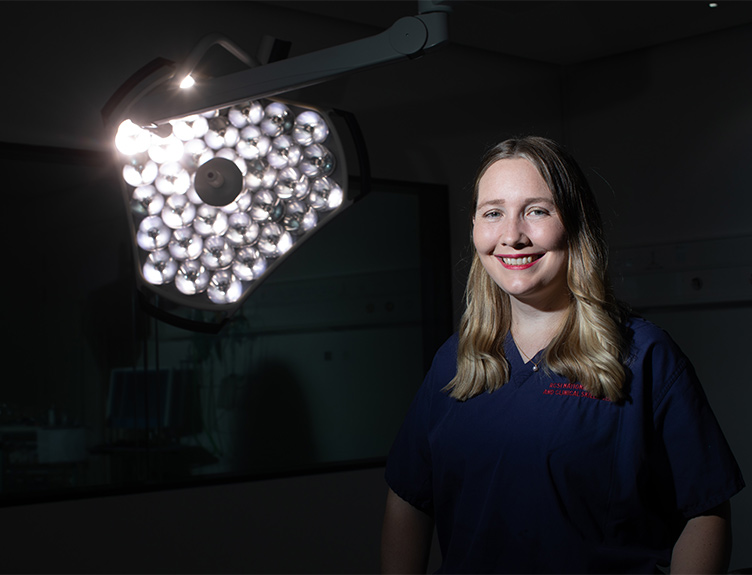 Dr Evelyn Murphy Dr Evelyn Murphy standing in a darkened operating theatre with surgical lights on