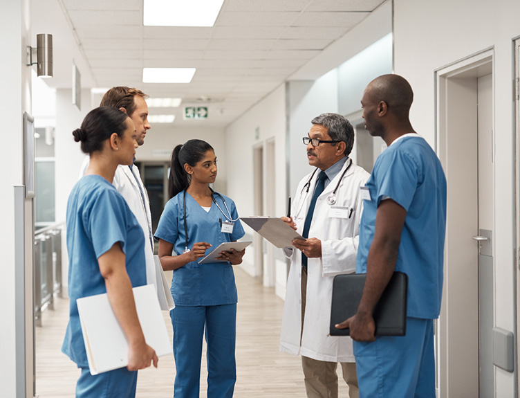 CPDSS Medical professionals conferring in a hospital corridor.