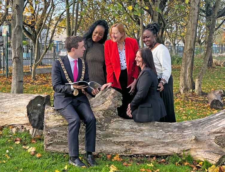 Feabhas project Man wearing gold Lord Mayors chain sits with four women in a green area