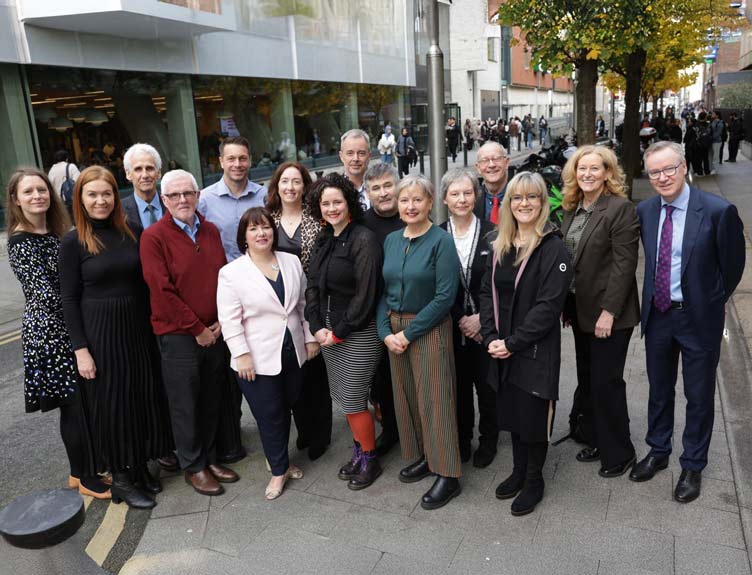 IPASTAR A large group pose for photo outside building in city centre.