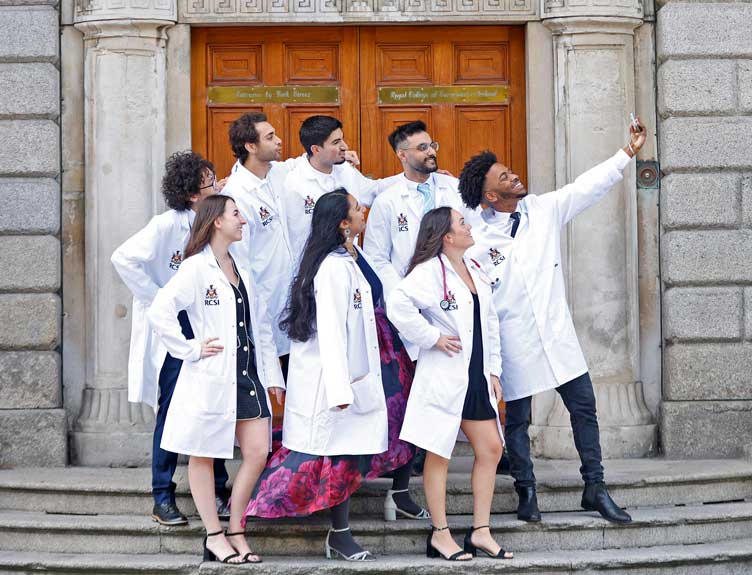White Coat Ceremony 2024 Group of students in white coats celebrate outside building