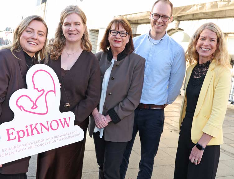 Five people at the launch of EpiKNOW with promotional signage