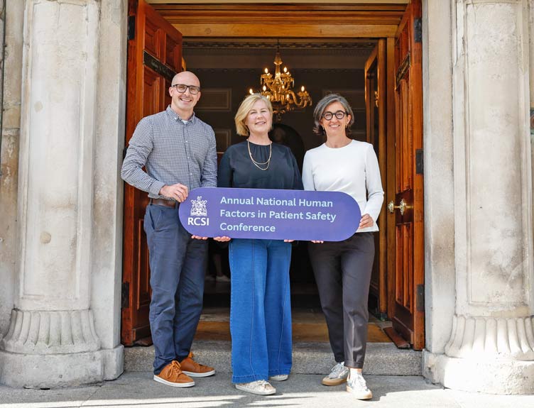 Three people hold up signage to promote RCSI's Human Factors conference