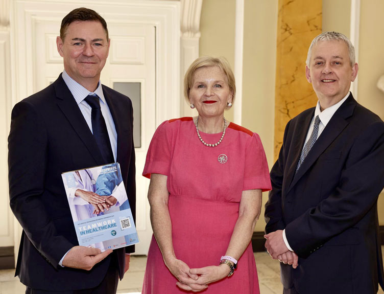Medical Professionalism Conference Group shot of three people with a printed publication