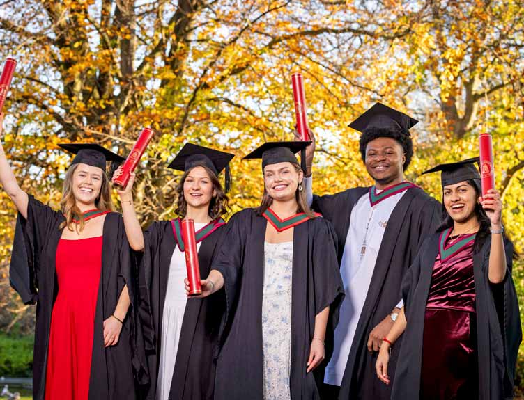 Group of students proudly display parchments in park after university conferring