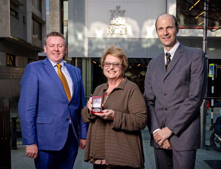 Professor Margaret A. Pericak-Vance is presented an award by two academics.