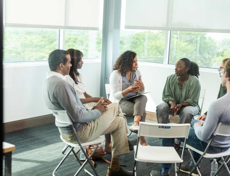 Diverse group of adults in a supportive group therapy session