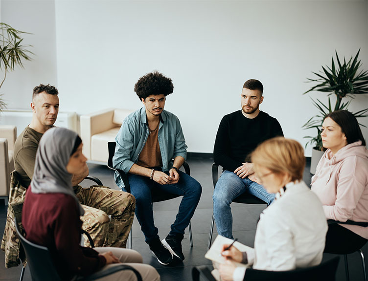 Six medical professionals and members of the public seated in a circle.