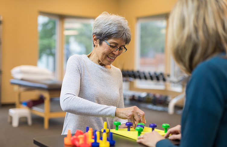 Senior woman does rehab with physiotherapist