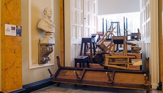 Chairs stacked beside a window in a historic building