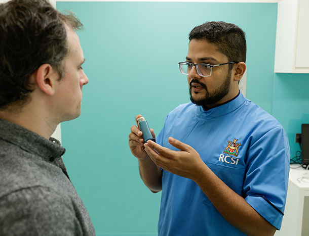 Nurse teaching patient to use inhaler