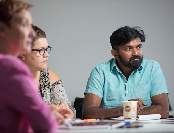 Three researchers around a conference table.