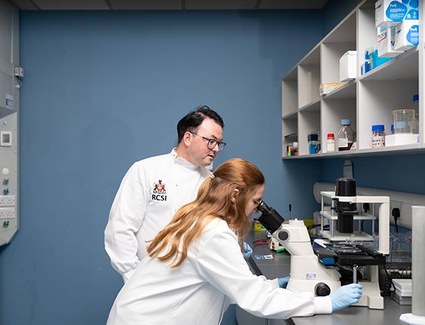 Two reseachers confer over a microscope