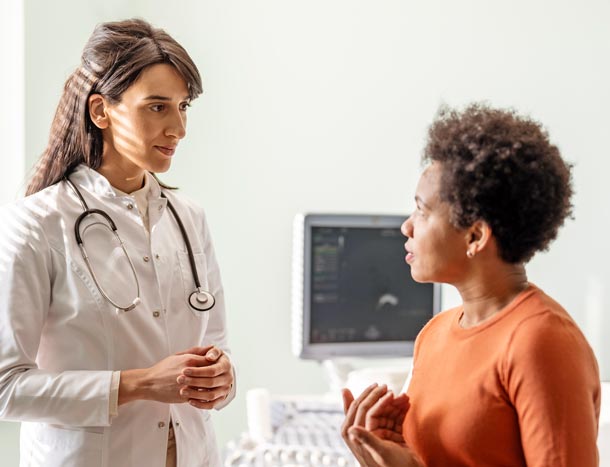 A female doctor talks with her patient in front of her as they talk about her concerns