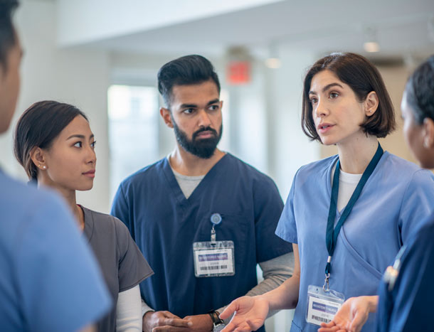 Clinicians conferring in a hospital setting.