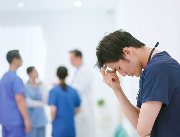 Stressed young doctor in hospital hallway