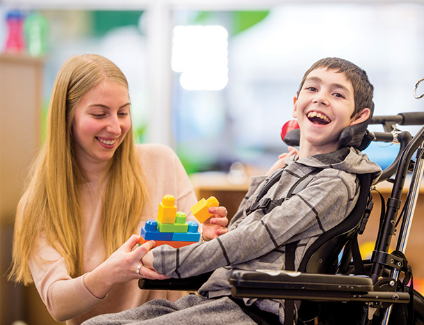 Young boy in wheelchair with carer