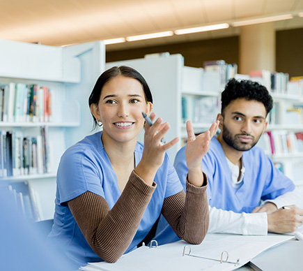 Two clinicians in discussion around a seminar table.
