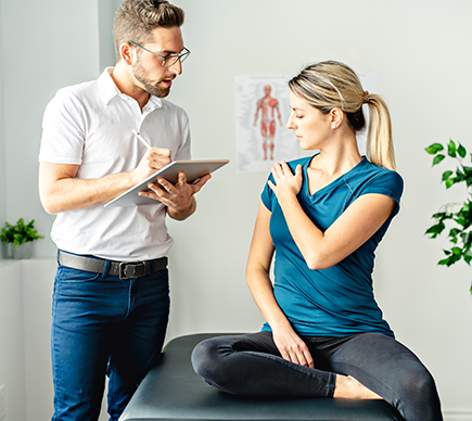 A physiotherapist examines a patient's shoulder