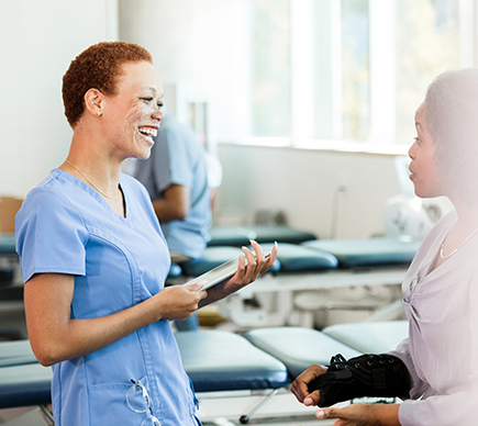 A nurse smiling with a colleague.