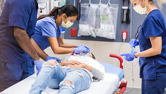 Doctors and nurses working on patient in ER
