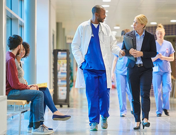 Doctors and hospital management in hallway